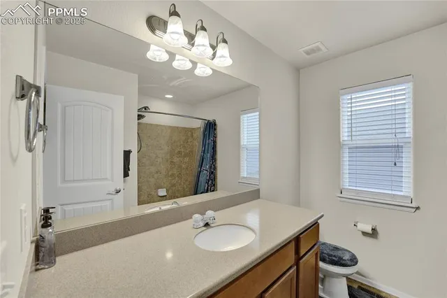 a bathroom with a granite countertop sink a large mirror and a shower
