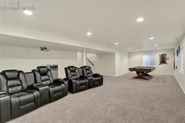 a living room with furniture pool table and windows