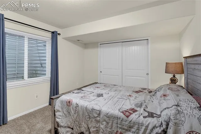 a bedroom with a bed and a refrigerator