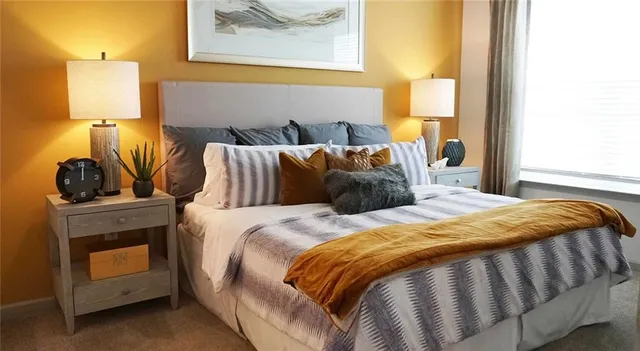 a bedroom with a bed and painting on the wall