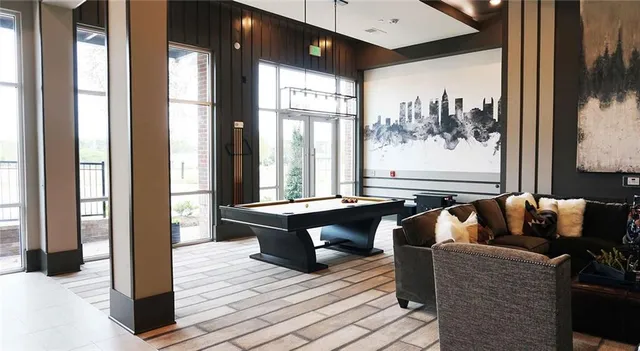 a living room with furniture a large window and wooden floor