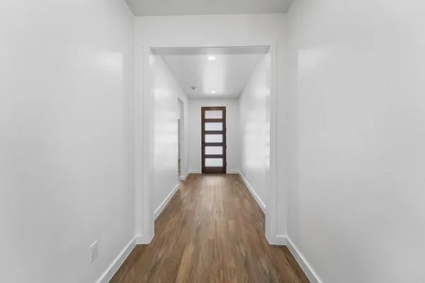 a view of a hallway with wooden floor and staircase