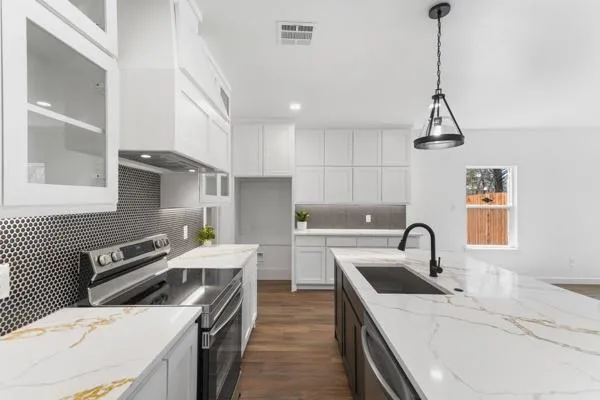 a kitchen that has a sink a stove and a table