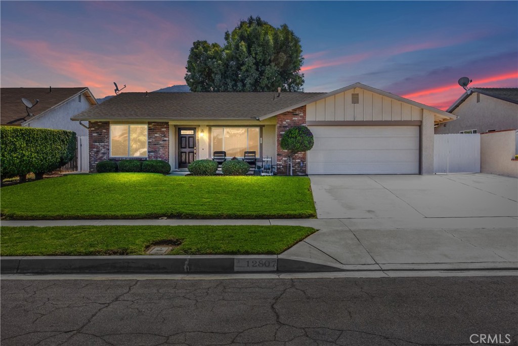 12807 Reed Avenue Grand Terrace, CA 92313 - Photo 1 of 1 a front view of a house with a yard and garage