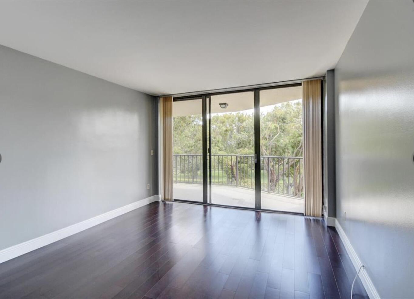 859 Jeffery Street, Unit 3030 Boca Raton, FL 33487 - Photo 7 of 24 a view of an empty room with wooden floor and a window