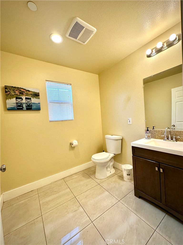 228 North Orange Avenue Rialto, CA 92376 - Photo 12 of 34 a bathroom with a sink mirror and toilet
