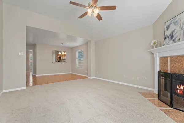 a view of a room with wooden floors and ceiling fan