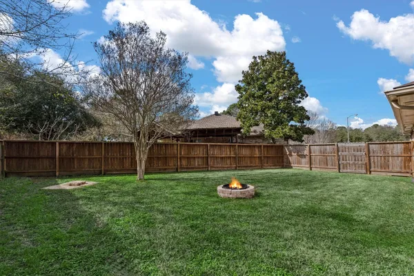 a view of a backyard with wooden fence