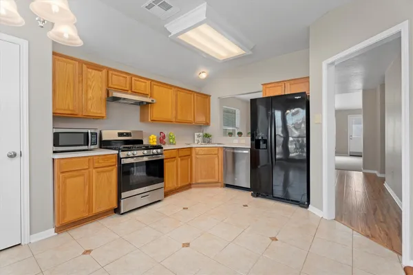 a kitchen with stainless steel appliances granite countertop a refrigerator and a sink