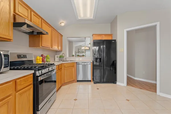 a kitchen with stainless steel appliances granite countertop a refrigerator and a stove