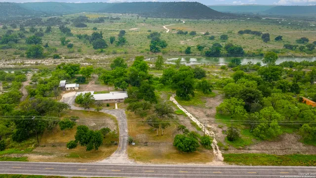 an aerial view of residential houses with outdoor space and trees