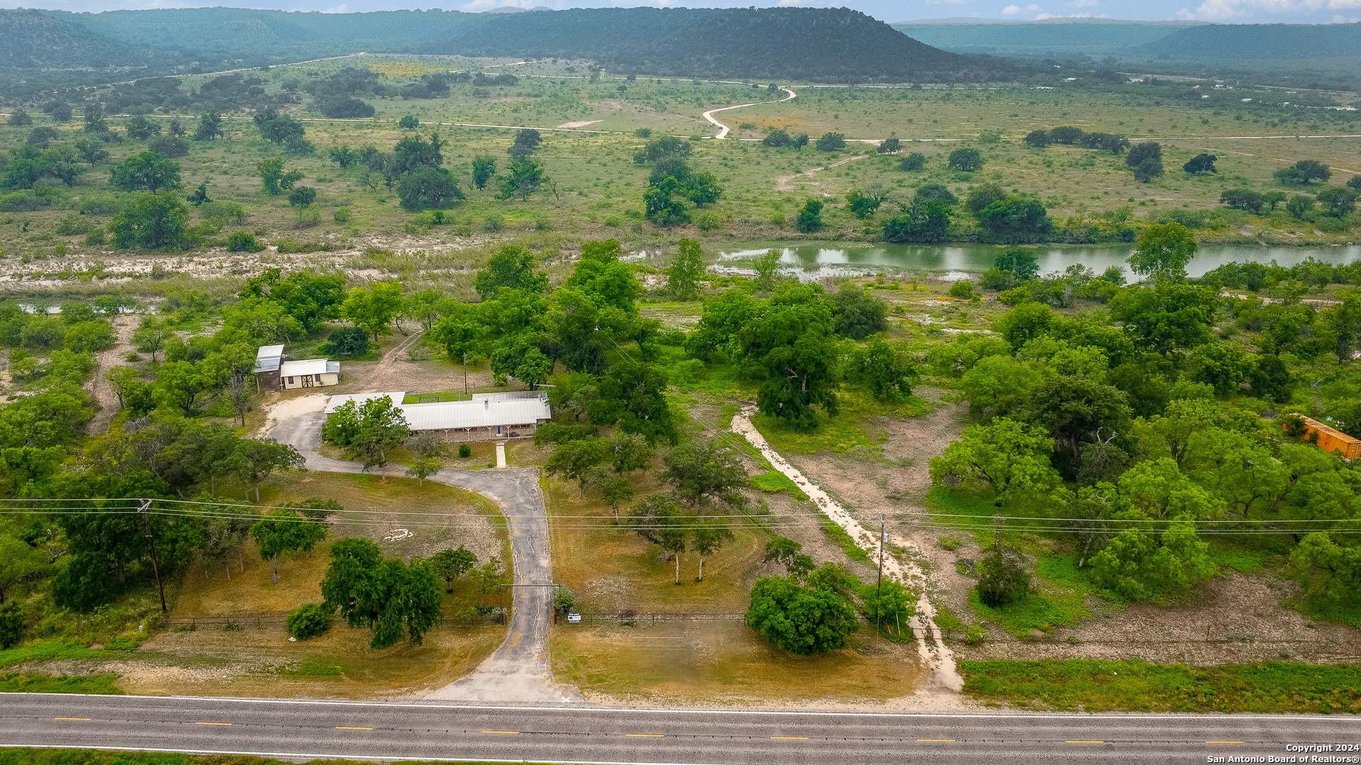an aerial view of residential houses with outdoor space and trees