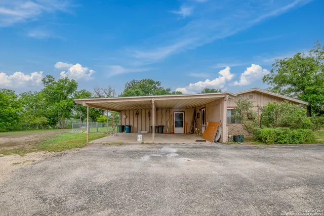 a front view of a house with a yard and potted plants