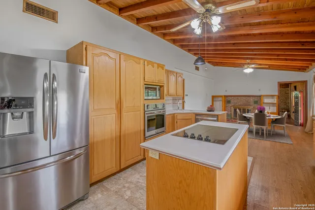 a kitchen with stainless steel appliances granite countertop a refrigerator a sink and a stove
