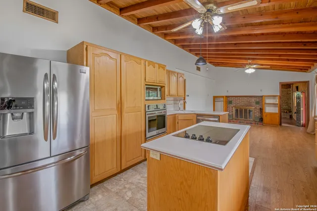 a kitchen with stainless steel appliances granite countertop a refrigerator a sink and a stove