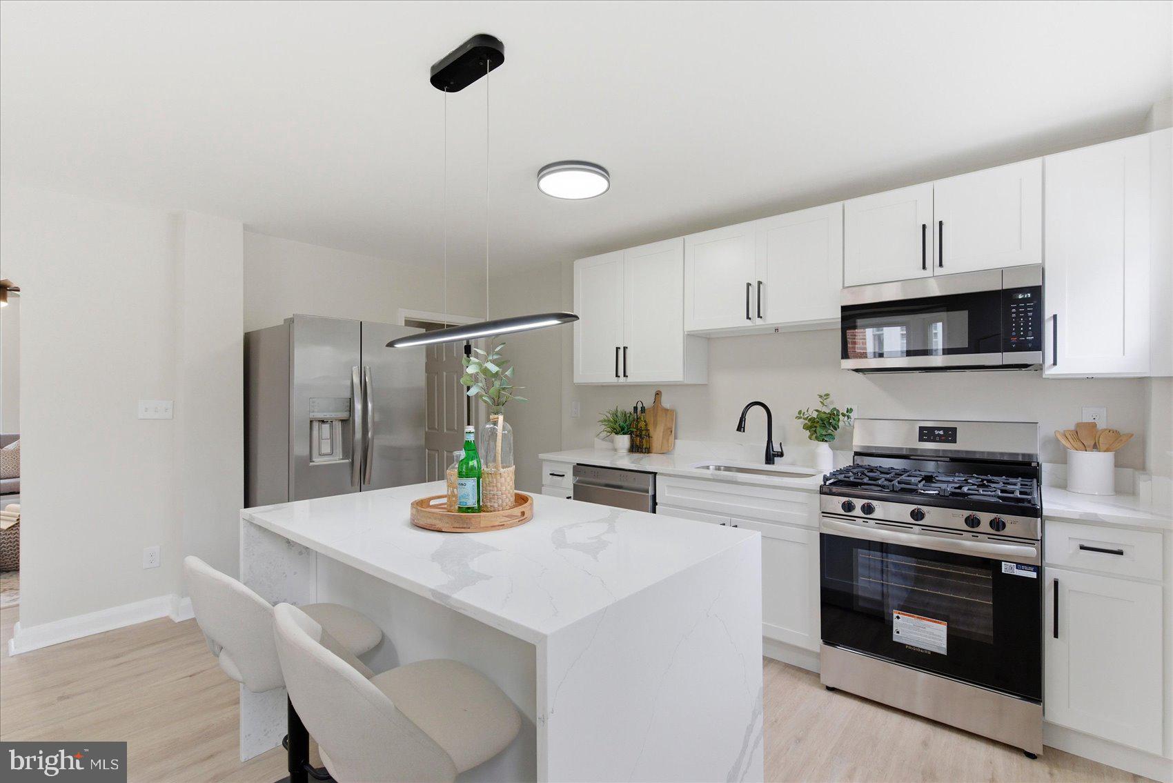 10 Mardrew Road Baltimore, MD 21229 - Photo 12 of 37 a kitchen with a sink a stove and white cabinets