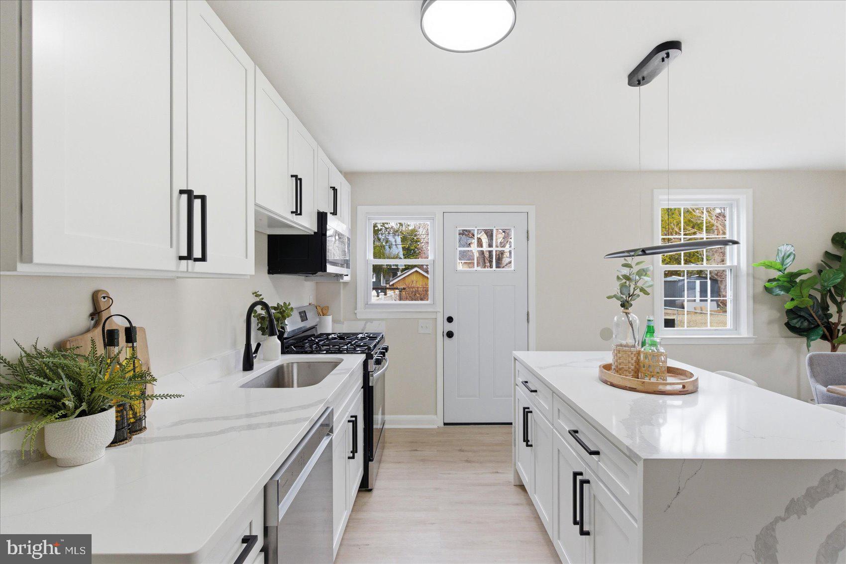 10 Mardrew Road Baltimore, MD 21229 - Photo 14 of 37 a kitchen with stainless steel appliances a sink a stove and white cabinets