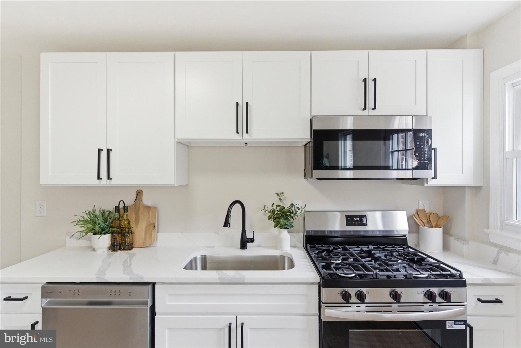 10 Mardrew Road Baltimore, MD 21229 - Photo 18 of 37 a kitchen with white cabinets a sink and appliances