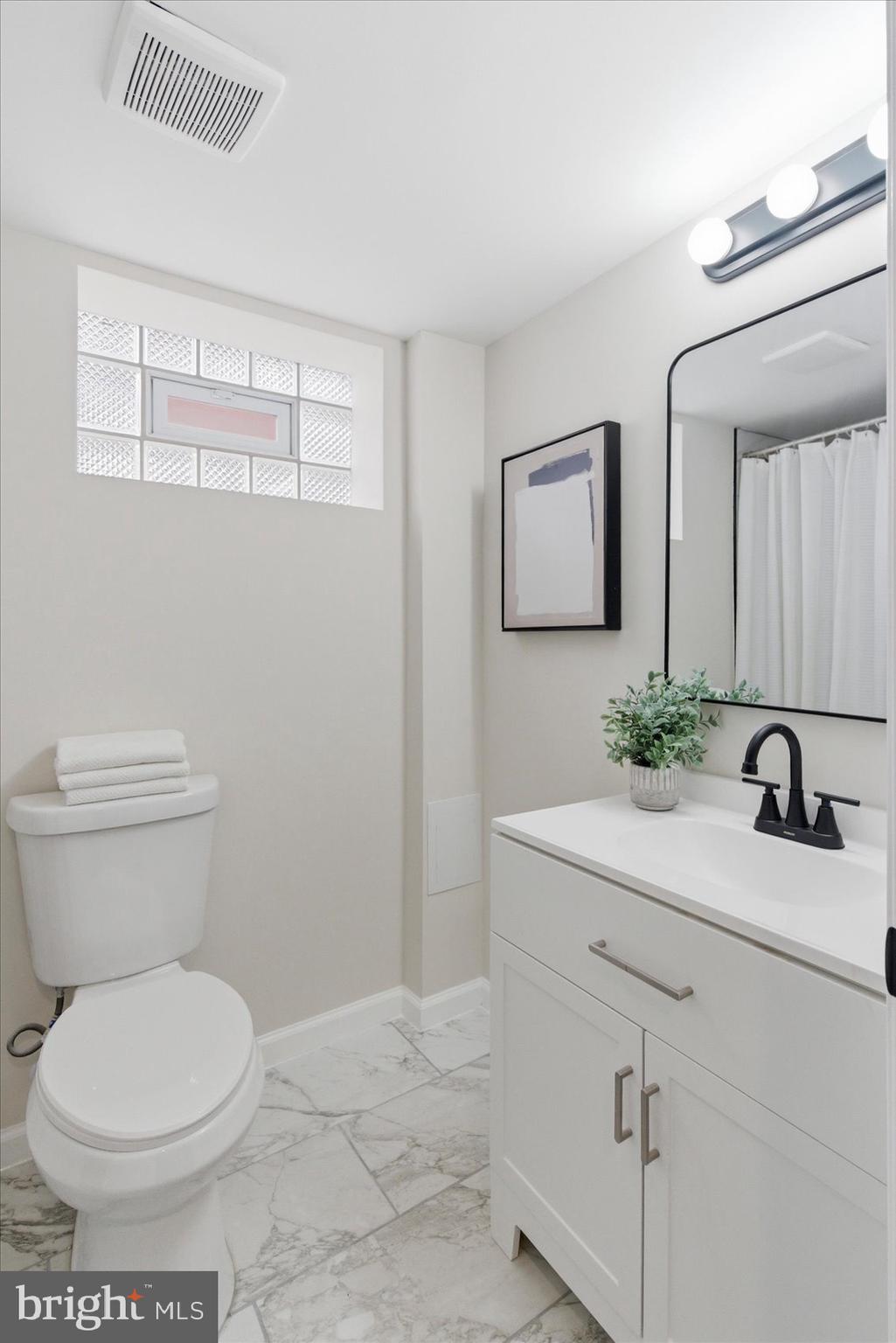 10 Mardrew Road Baltimore, MD 21229 - Photo 32 of 37 a bathroom with a toilet a sink and mirror