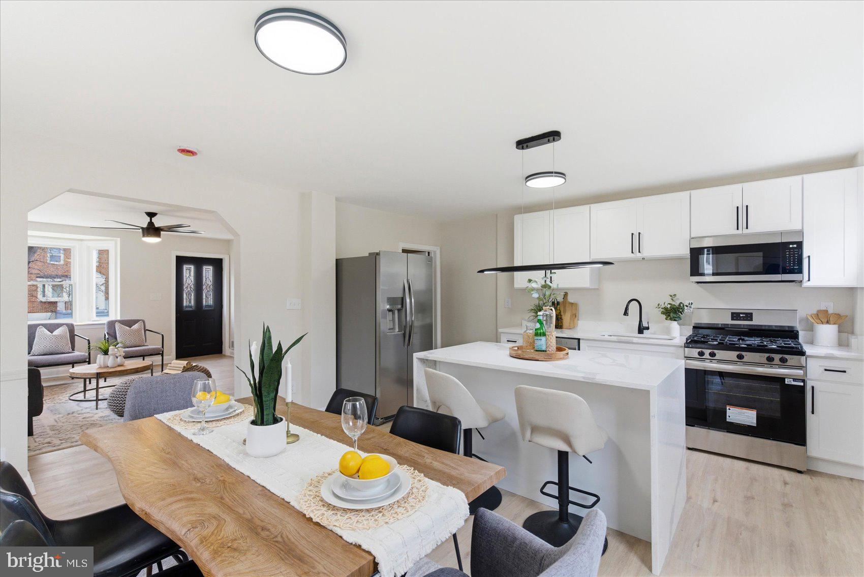 10 Mardrew Road Baltimore, MD 21229 - Photo 10 of 37 a kitchen with stainless steel appliances stove refrigerator dining table and chairs