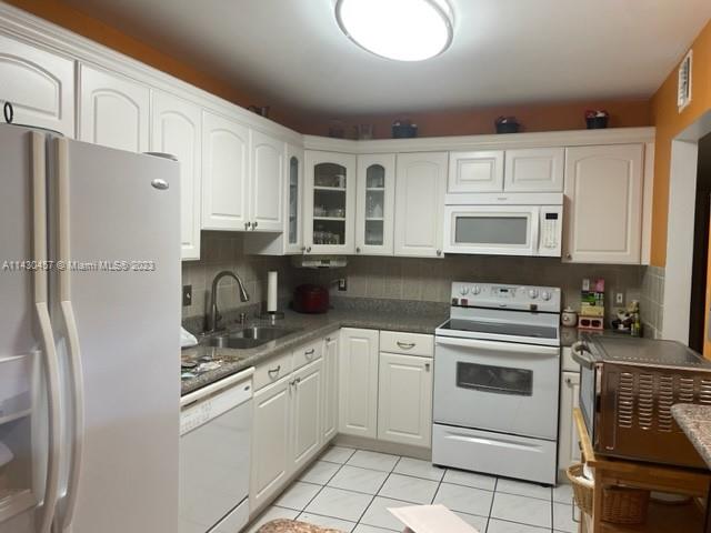 a kitchen with white cabinets and white appliances