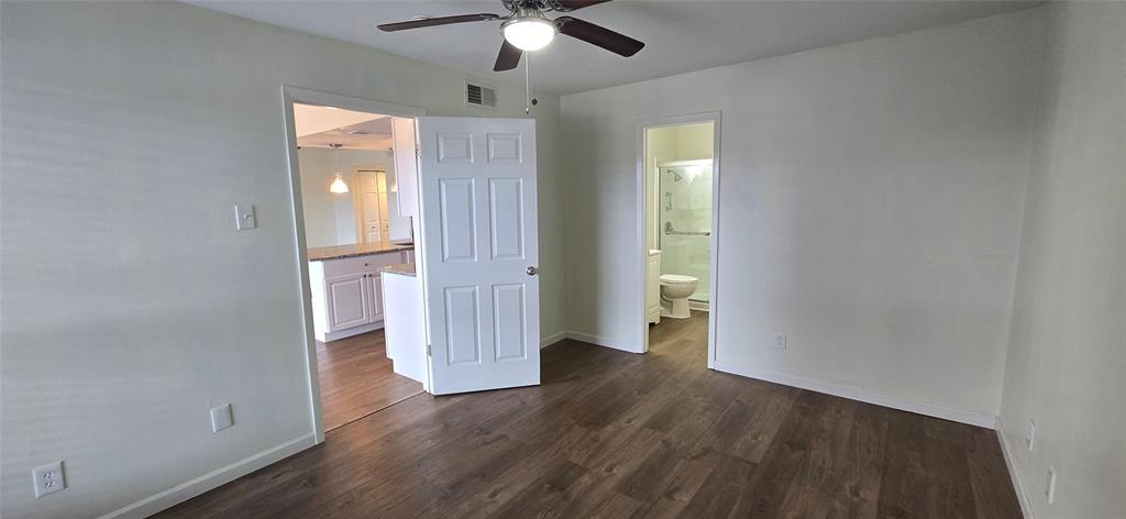 4484 Chaha Road, Unit 103 Garland, TX 75043 - Photo 4 of 13 an empty room with wooden floor chandelier fan and windows