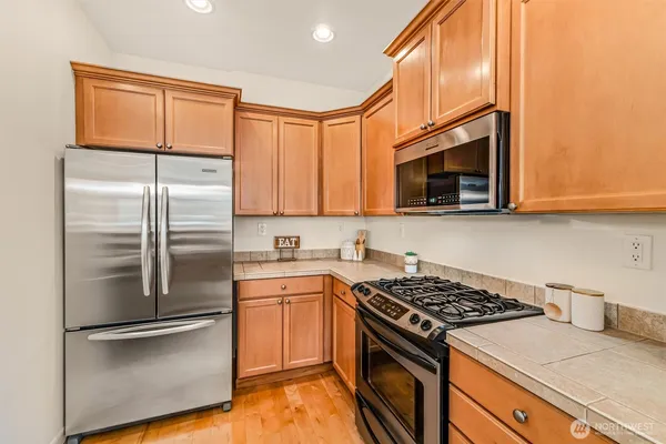 a kitchen with stainless steel appliances granite countertop a sink a stove and a refrigerator