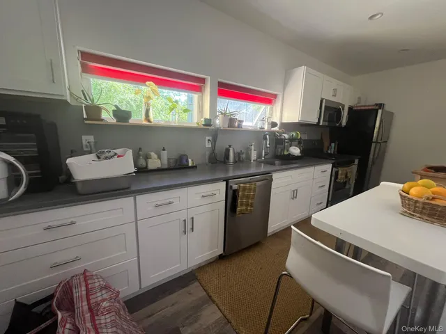 a kitchen with a sink cabinets and wooden floor