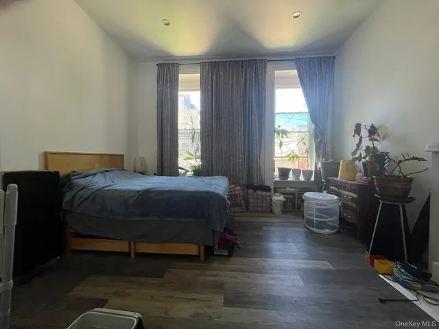 a bedroom with a bed and windows