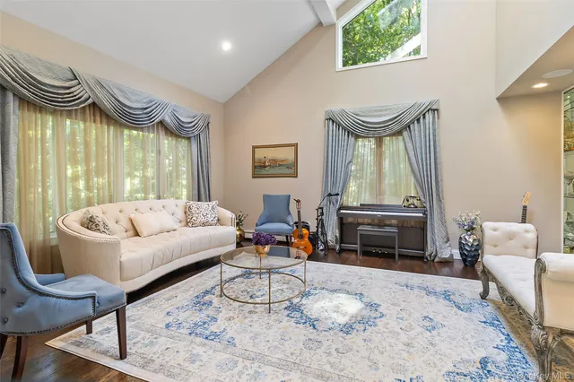 a living room with furniture a fireplace and a floor to ceiling window