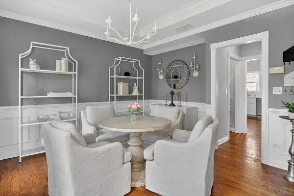 a living room with furniture a chandelier and wooden floor