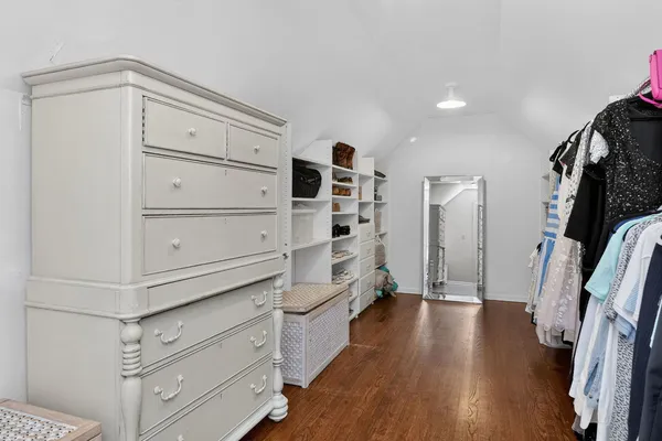 a view of walk in closet with clothes and shoes