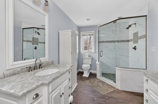 a bathroom with a granite countertop sink toilet and shower