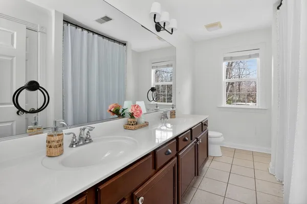 a bathroom with a granite countertop sink a mirror and a shower