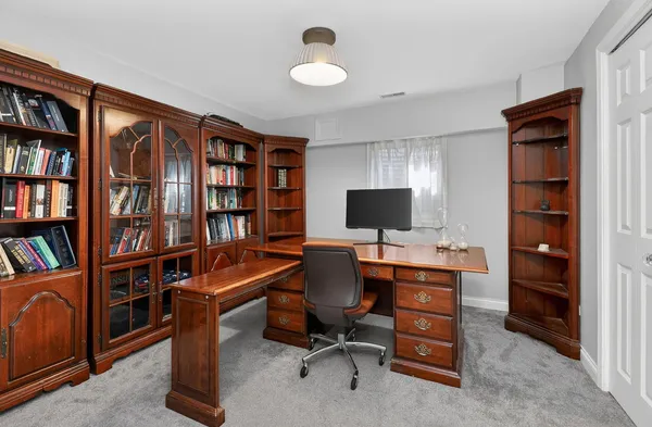 a view of a workspace with furniture and a bookshelf