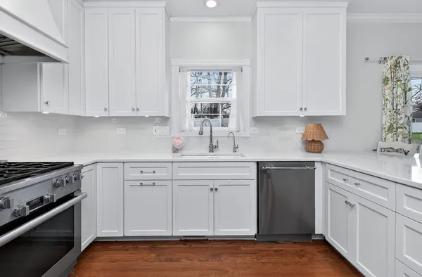 a kitchen with white cabinets and appliances
