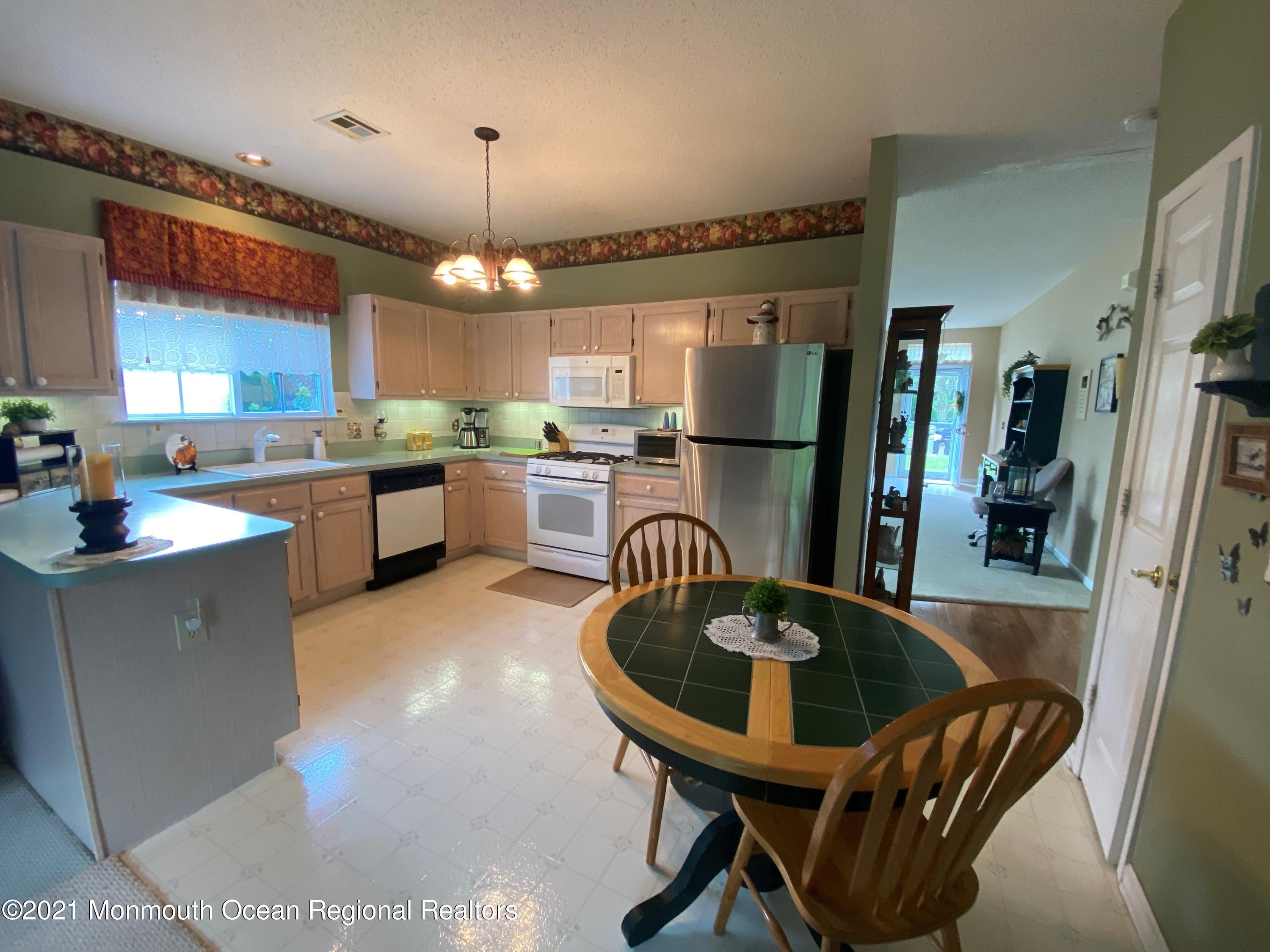 47 Sandpiper Road Barnegat, NJ 08005 - Photo 7 of 15 a kitchen with kitchen island a dining table chairs stainless steel appliances and cabinets