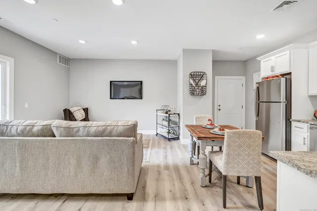 a living room with furniture and a refrigerator