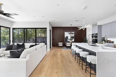 a large white kitchen with a large window and stainless steel appliances
