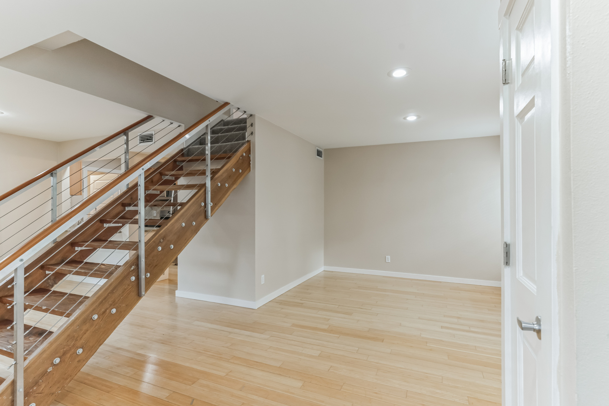 3214 Clawson Road, Unit A Austin, TX 78704 - Photo 3 of 26 Modern wood and steel staircase complements light hardwood flooring in this versatile living space.