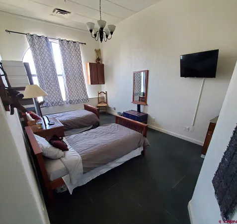 a bedroom with bed tv and window