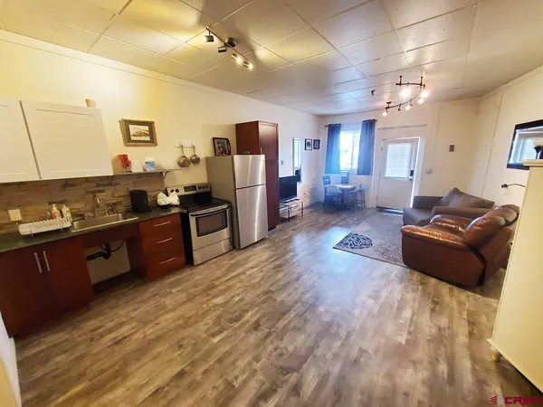 a living room with furniture windows and a flat screen tv