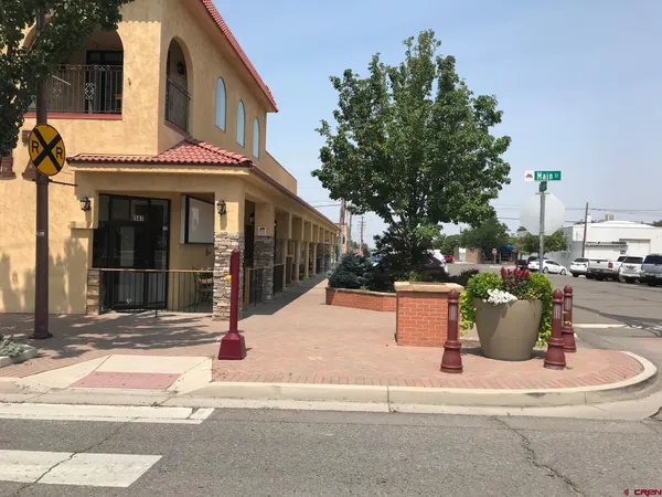 a view of a patio with table and chairs potted plants and large tree