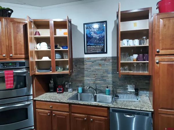 a kitchen with stainless steel appliances granite countertop a refrigerator and a sink