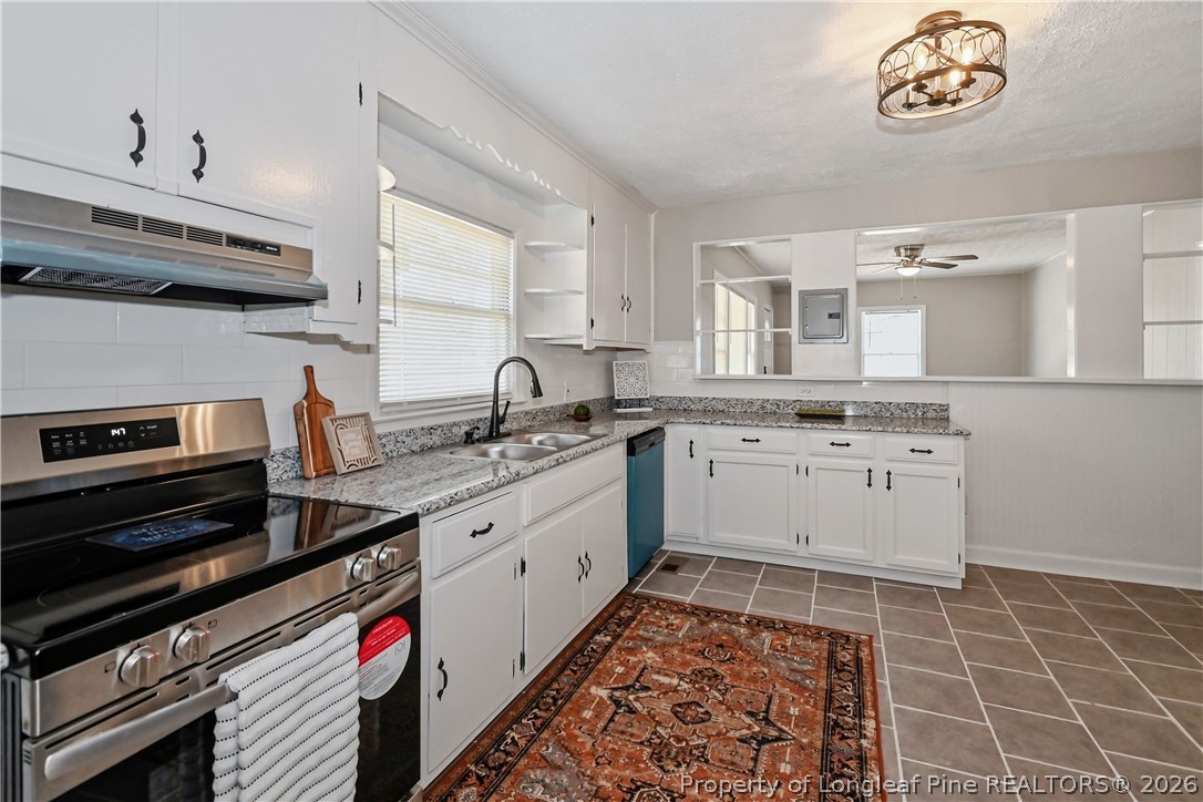 5307 Cypress Road Fayetteville, NC 28304 - Photo 13 of 36 a kitchen with a stove a sink and a microwave