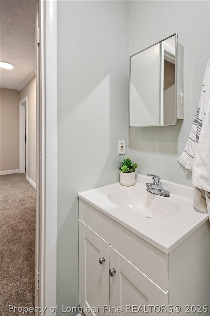 5307 Cypress Road Fayetteville, NC 28304 - Photo 25 of 36 a bathroom with a sink a vanity and a mirror