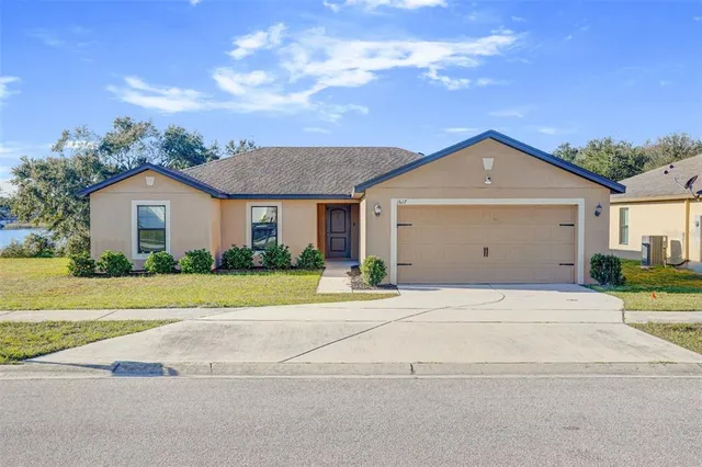 a front view of a house with a yard and garage