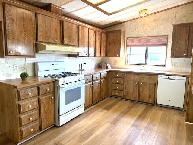 a kitchen with stainless steel appliances granite countertop a stove a sink dishwasher and a refrigerator