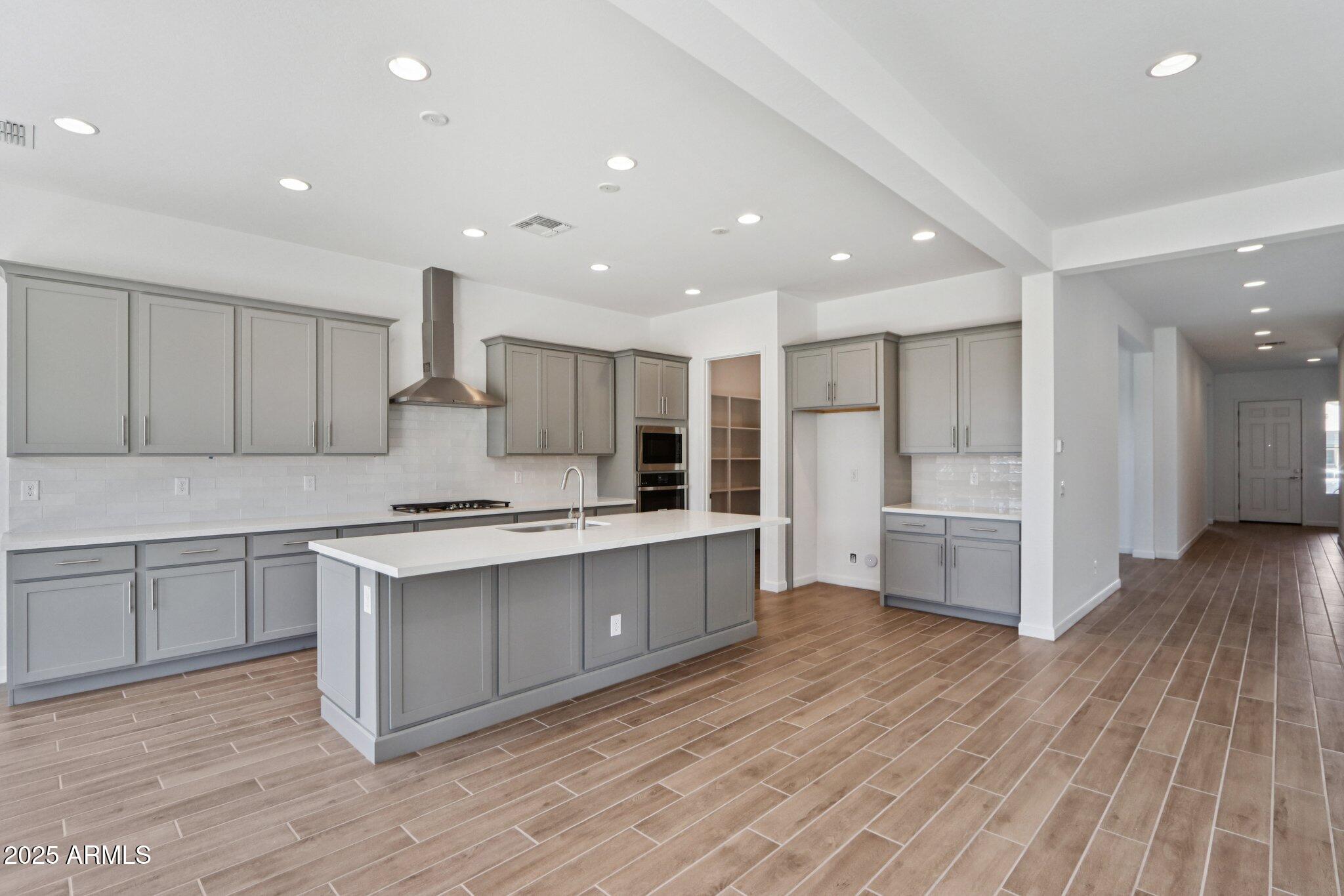 11417 East Utah Avenue Mesa, AZ 85212 - Photo 11 of 55 a large kitchen with stainless steel appliances granite countertop a large counter top a sink and a stove