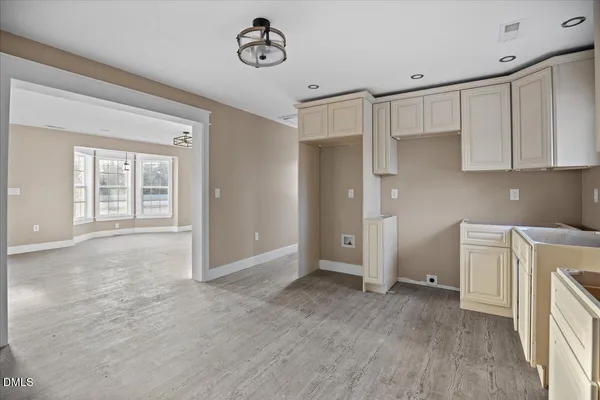 an empty room with a cabinet and mirrors